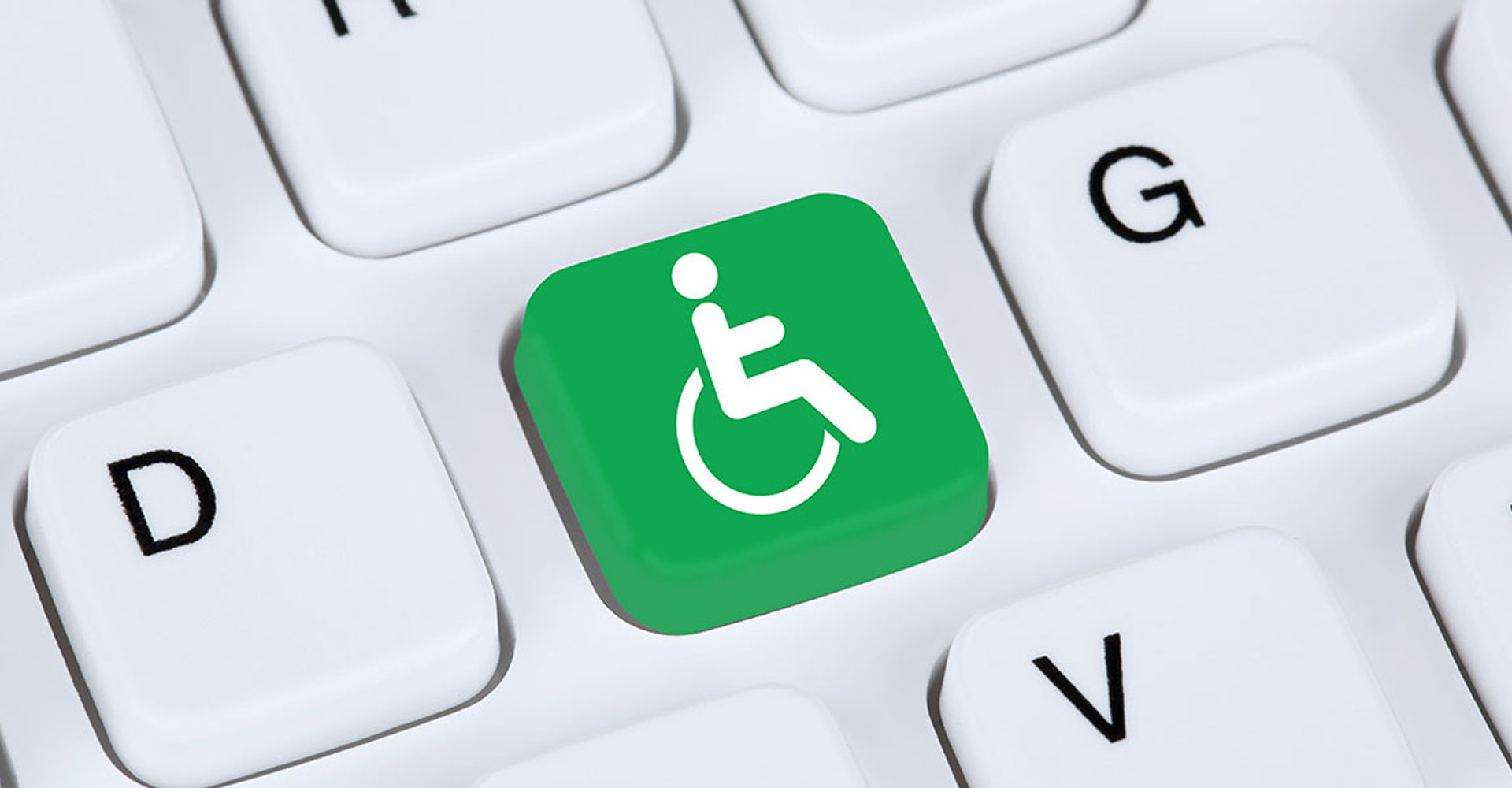 Phot of a close up of a keyboard featuring a bright green key with the handicap icon on it