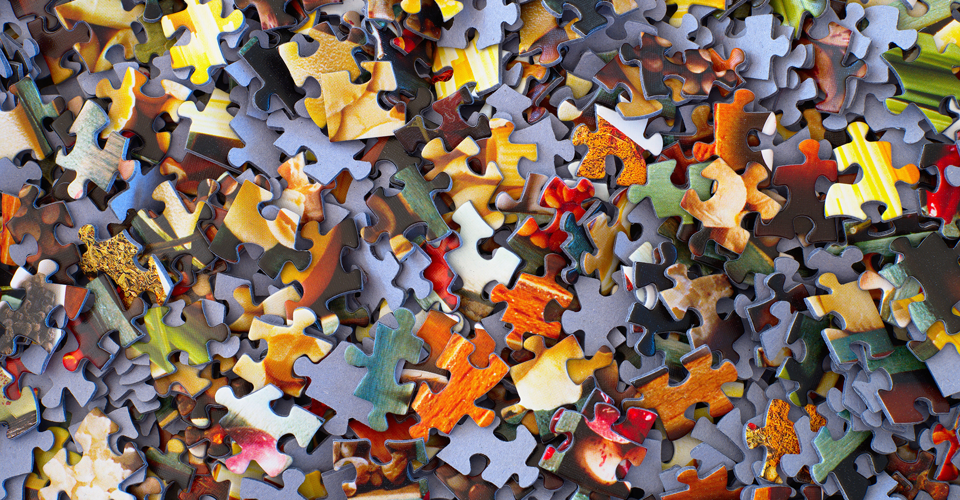 Photo of puzzle pieces in a pile shot from above.